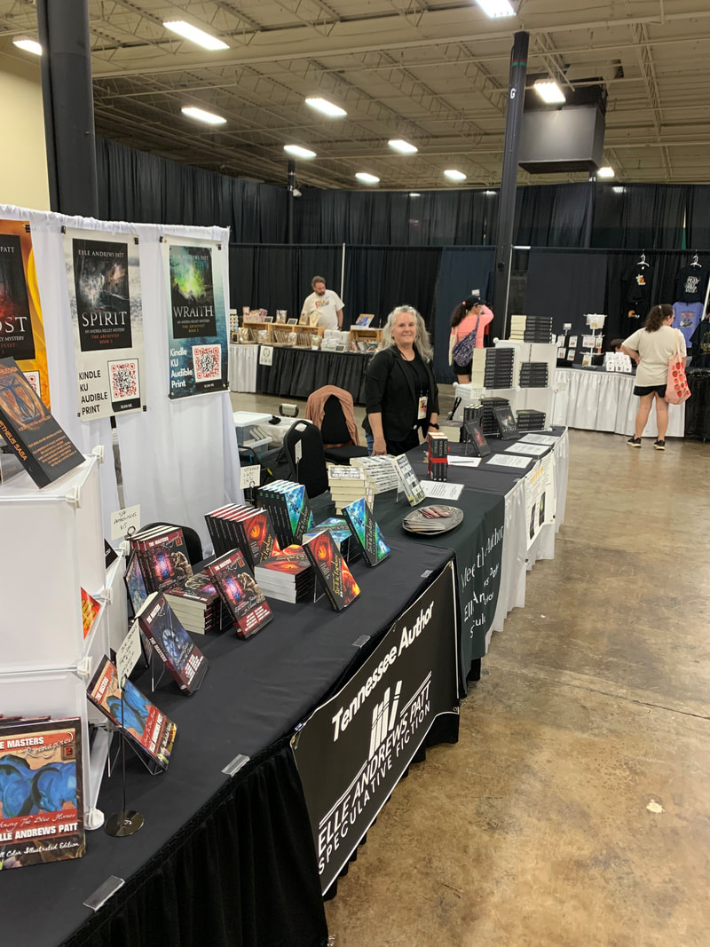 Elle at 16 foot table with mystery series and SFF anthologies